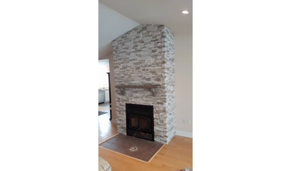 cultured stone with factory built fireplace, North shore. Lime stone mantle installed.